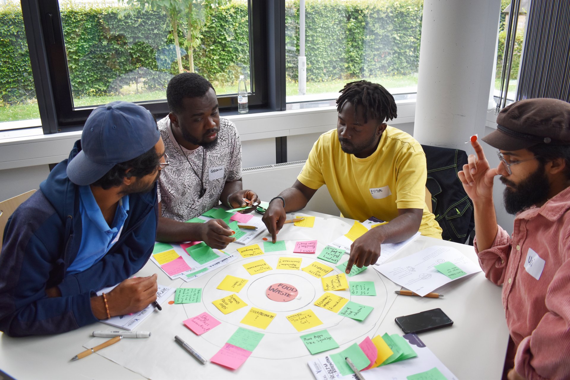 Four students sit at a table and discuss their business idea
